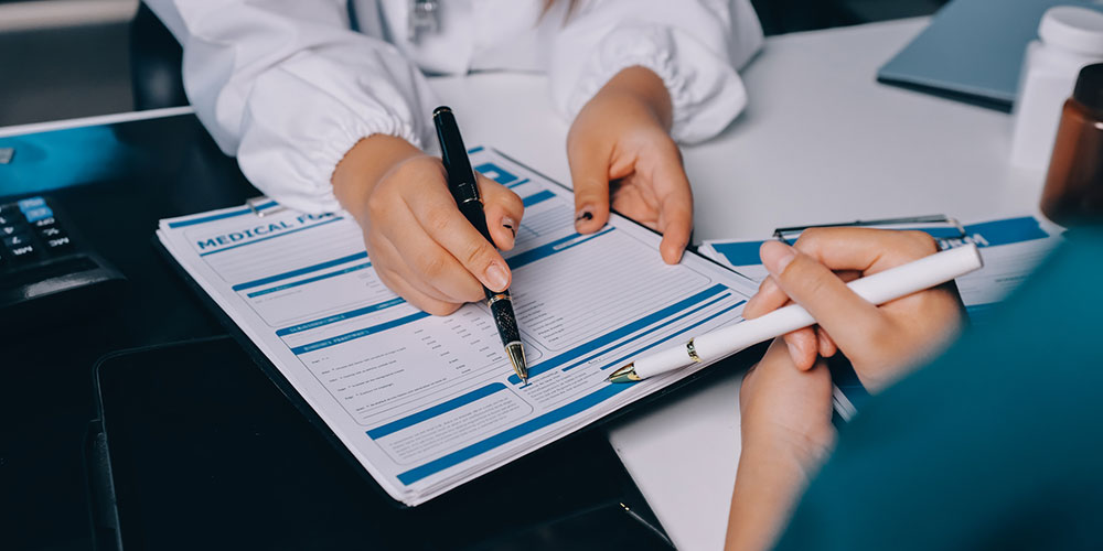 Doctor consultation and medical chart concept image, representing bankruptcy options for out-of-state medical bills affecting Florida residents