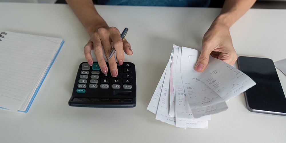 Budgeting and expense tracking concept image with receipts and a calculator, representing payday loan debt and bankruptcy relief in Florida