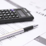 Financial statement review concept image with calculator and pen, representing private student loans and bankruptcy options in Florida.