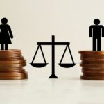 Balance scale between male and female figures standing on stacks of coins symbolizing debt division in divorce and bankruptcy